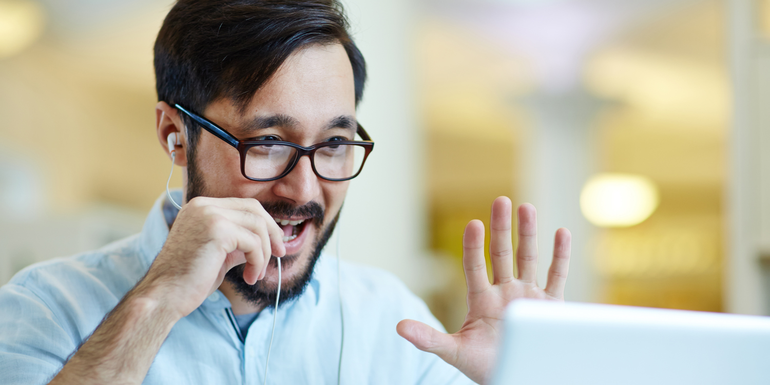 White Man Greeting Others On Laptop
